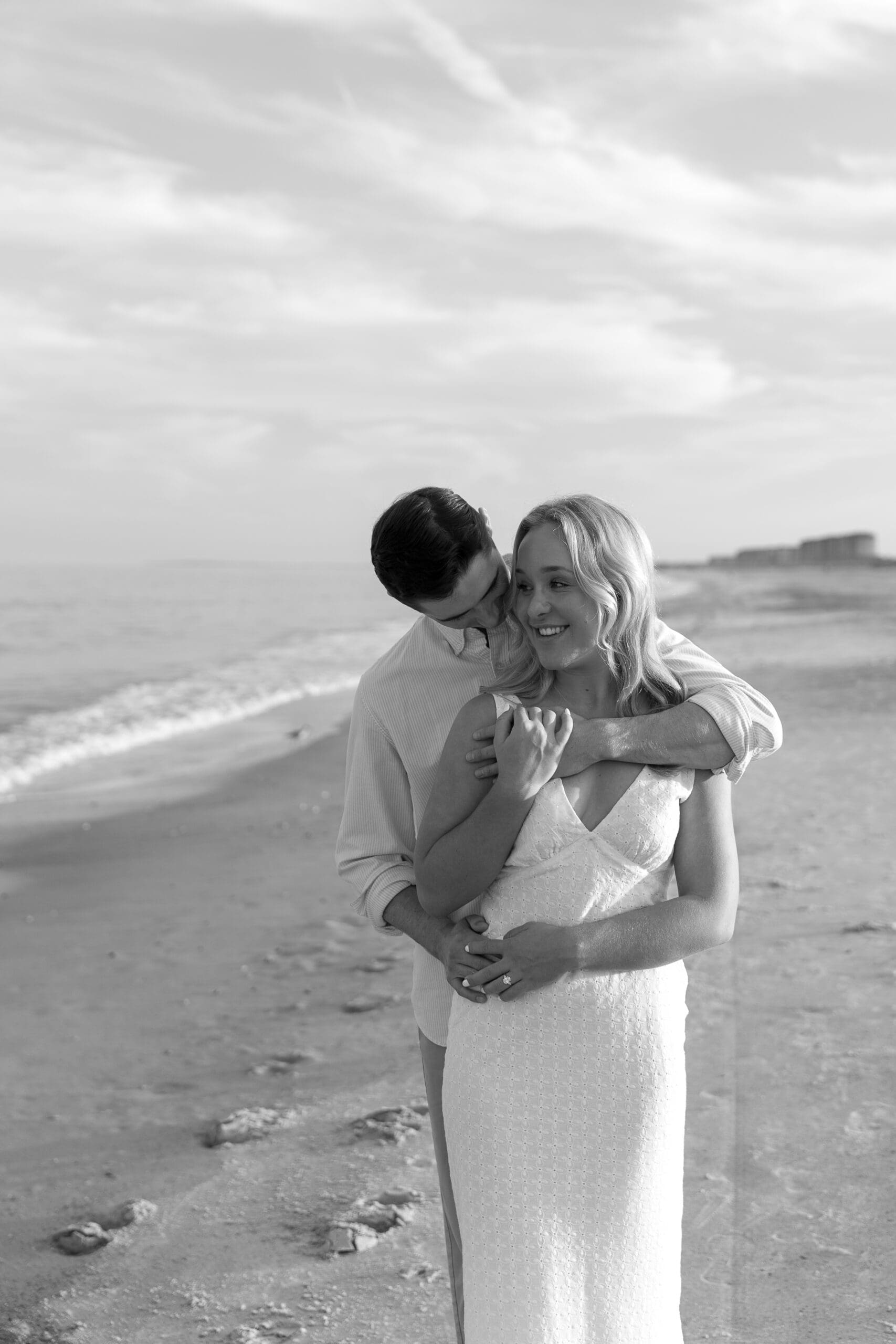 Groom wrapping up bride in hug from behind on Amelia Island