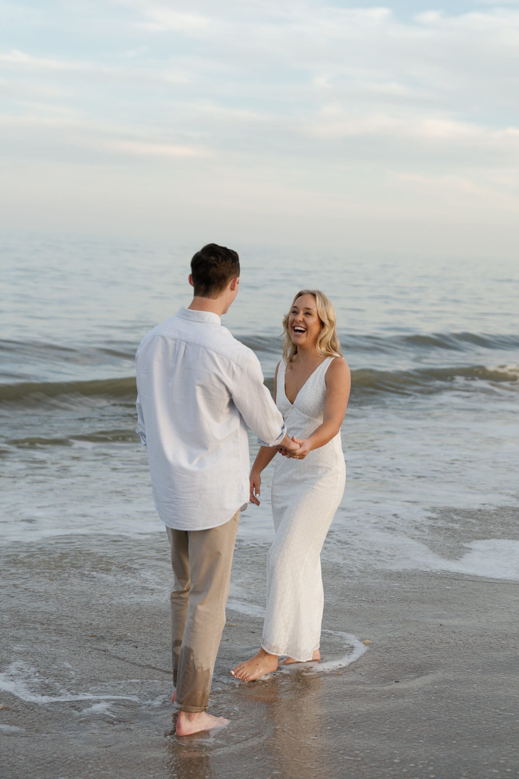 Couple laughing together at the beach walking in the water