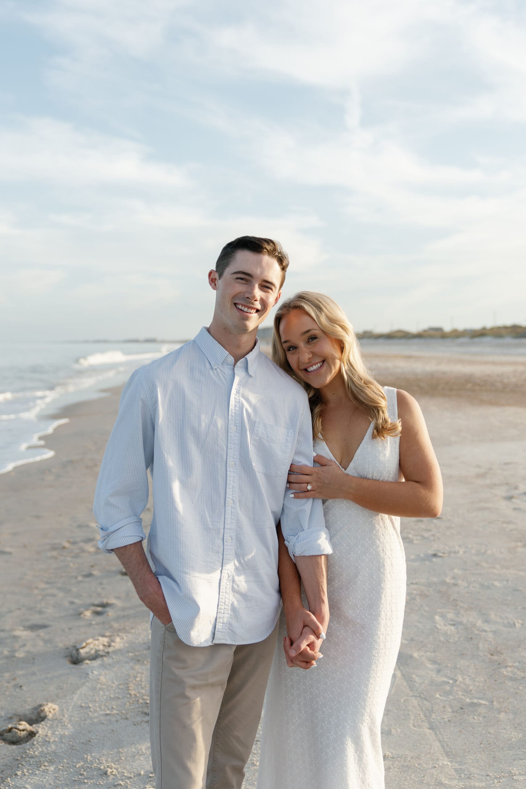 Couple holding hands at smiling at camera for Amelia Island beach session