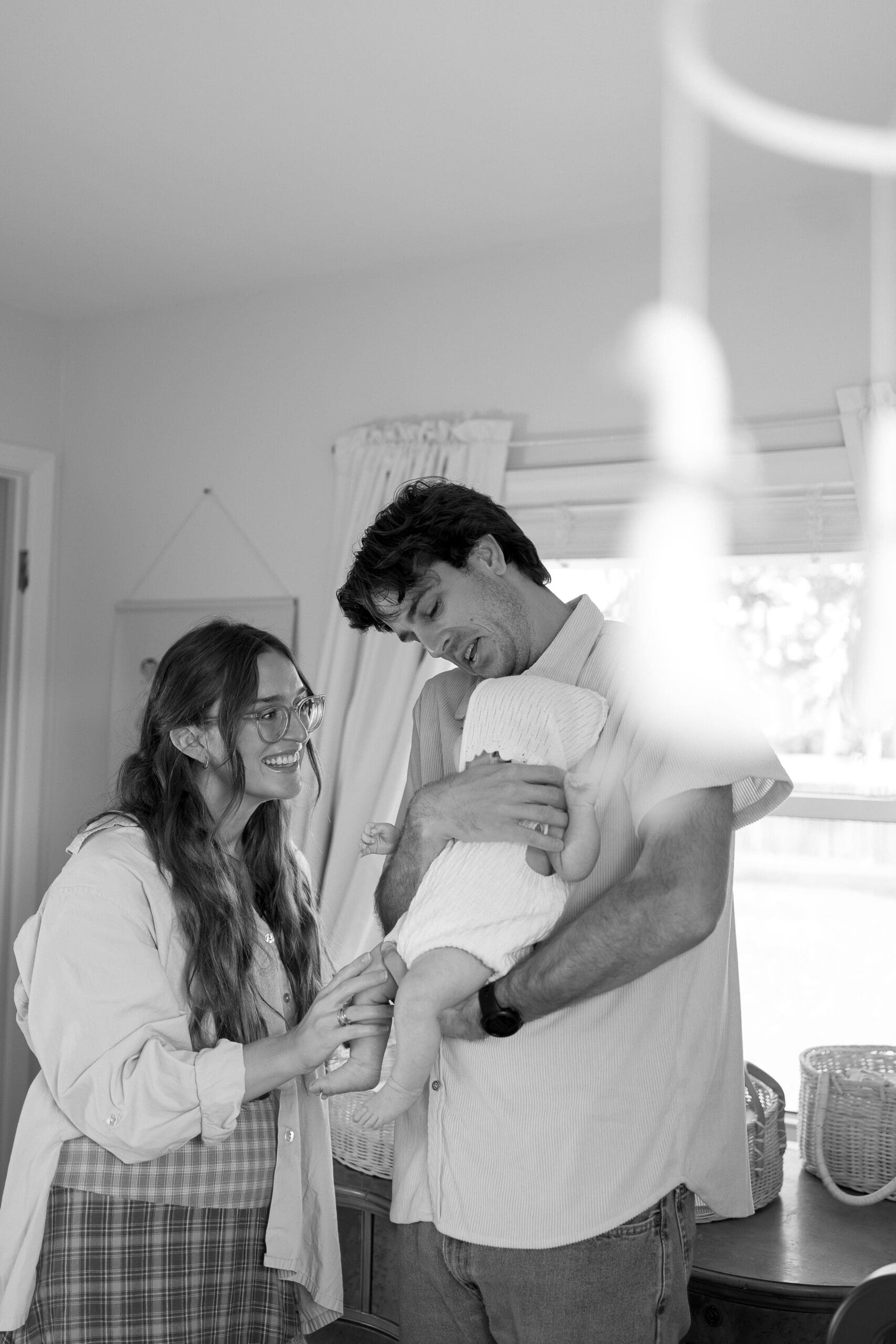 Parents holding their newborn baby and smiling