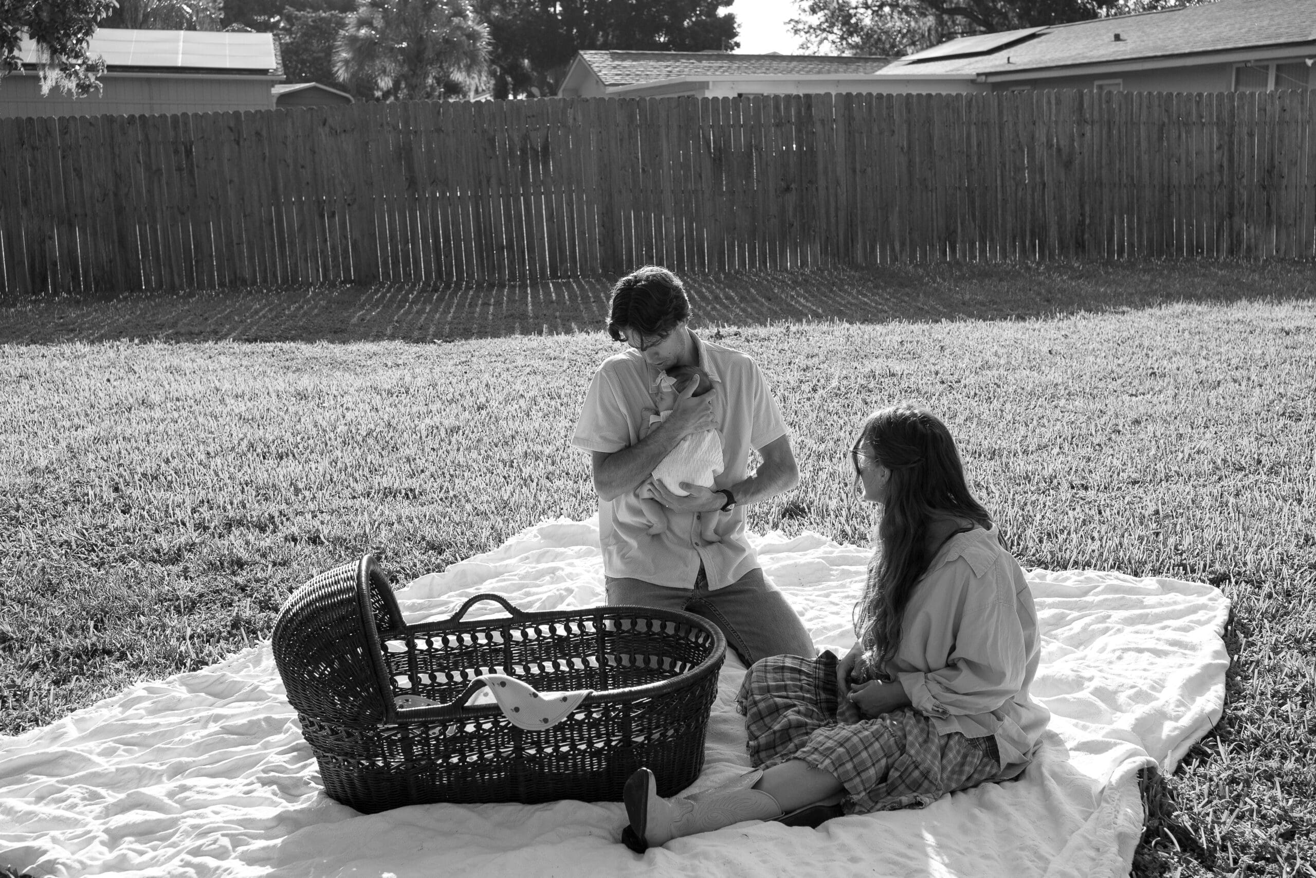 Couple holding baby at a backyard picnic