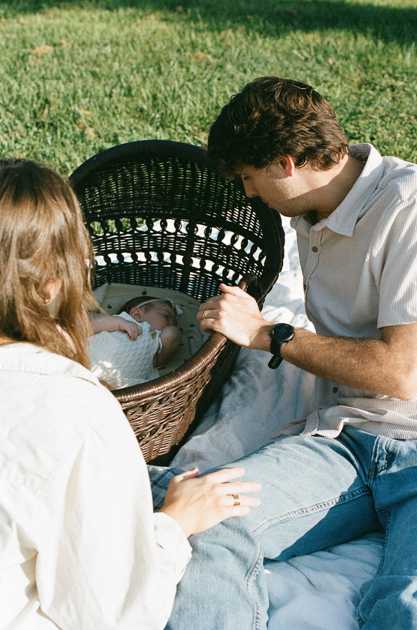 Couple looking at baby sleeping in bassinet