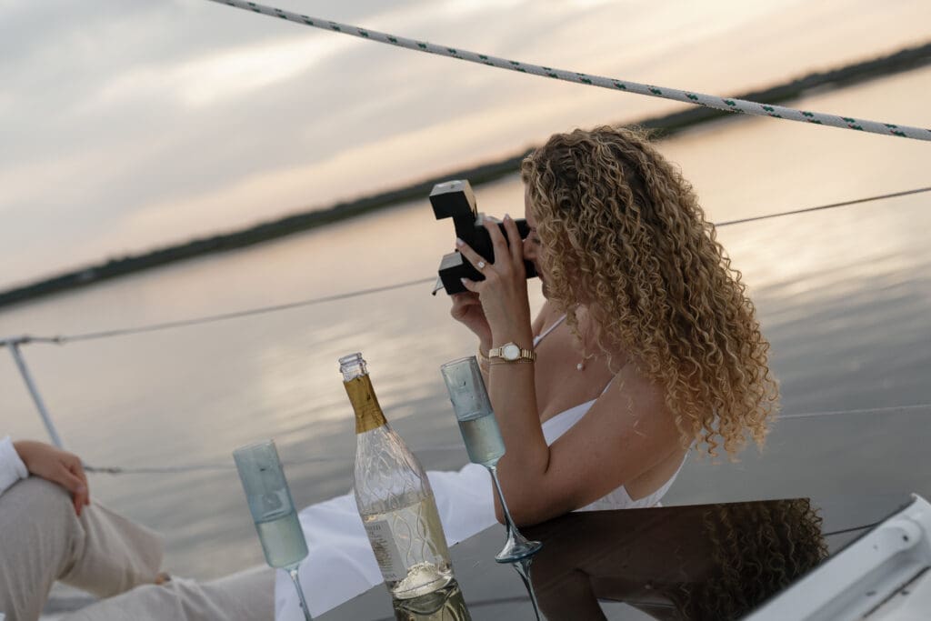 Girl taking picture on a polaroid couple during engagement session