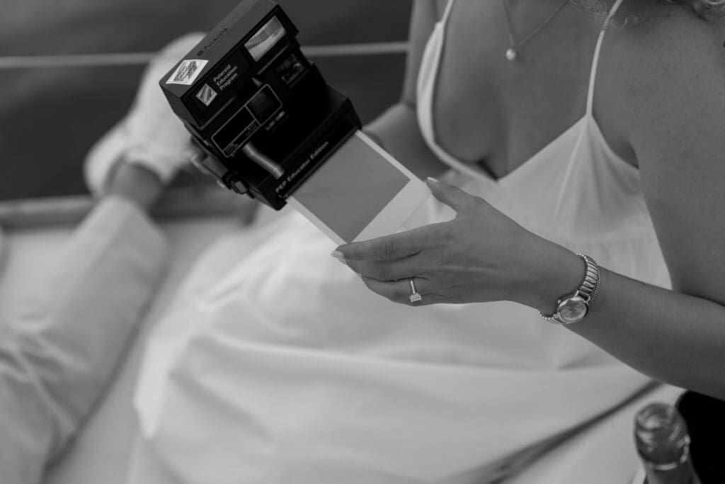Detail photo of polaroid camera and engagement ring for engagement session