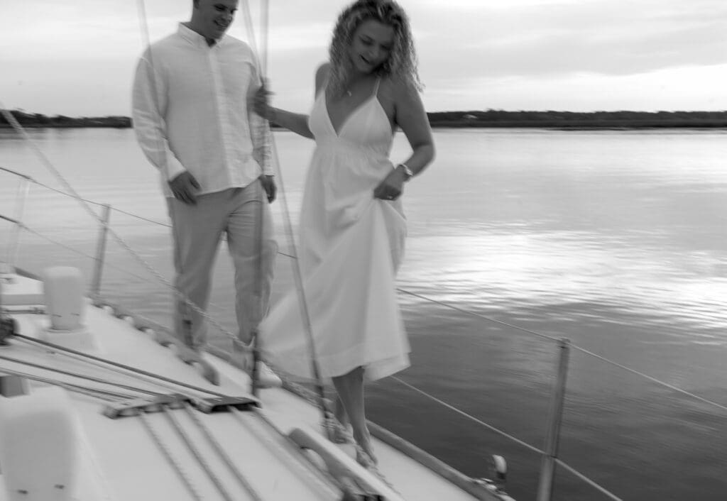Couple running on a sailboat and holding dress