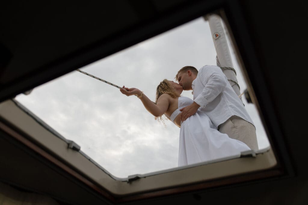 Couple kissing on a sailboat taken by Shelby Ann Photos for an engagement session