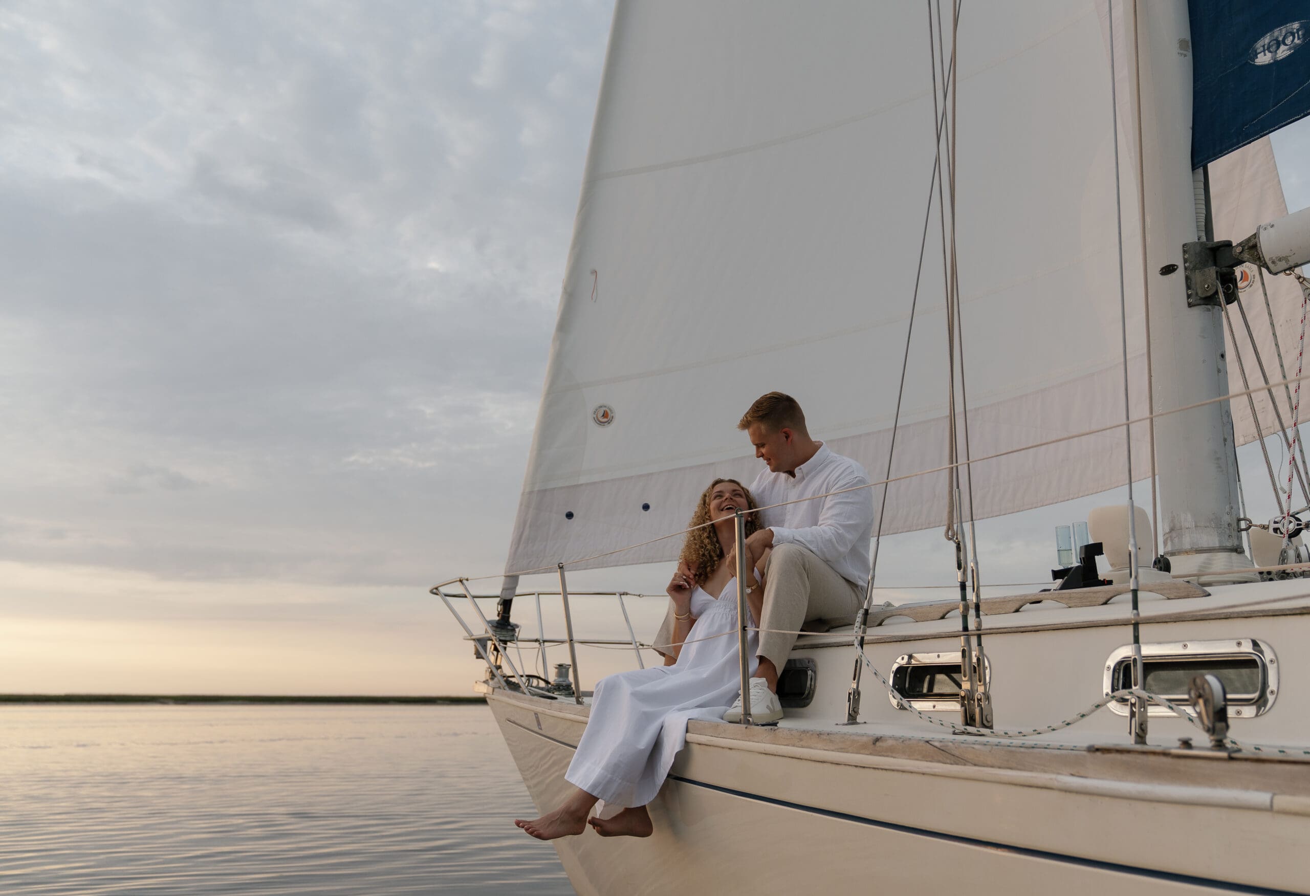 Couple sitting on a sailboat looking at each other for engagement photos taken by Shelby Ann Photos