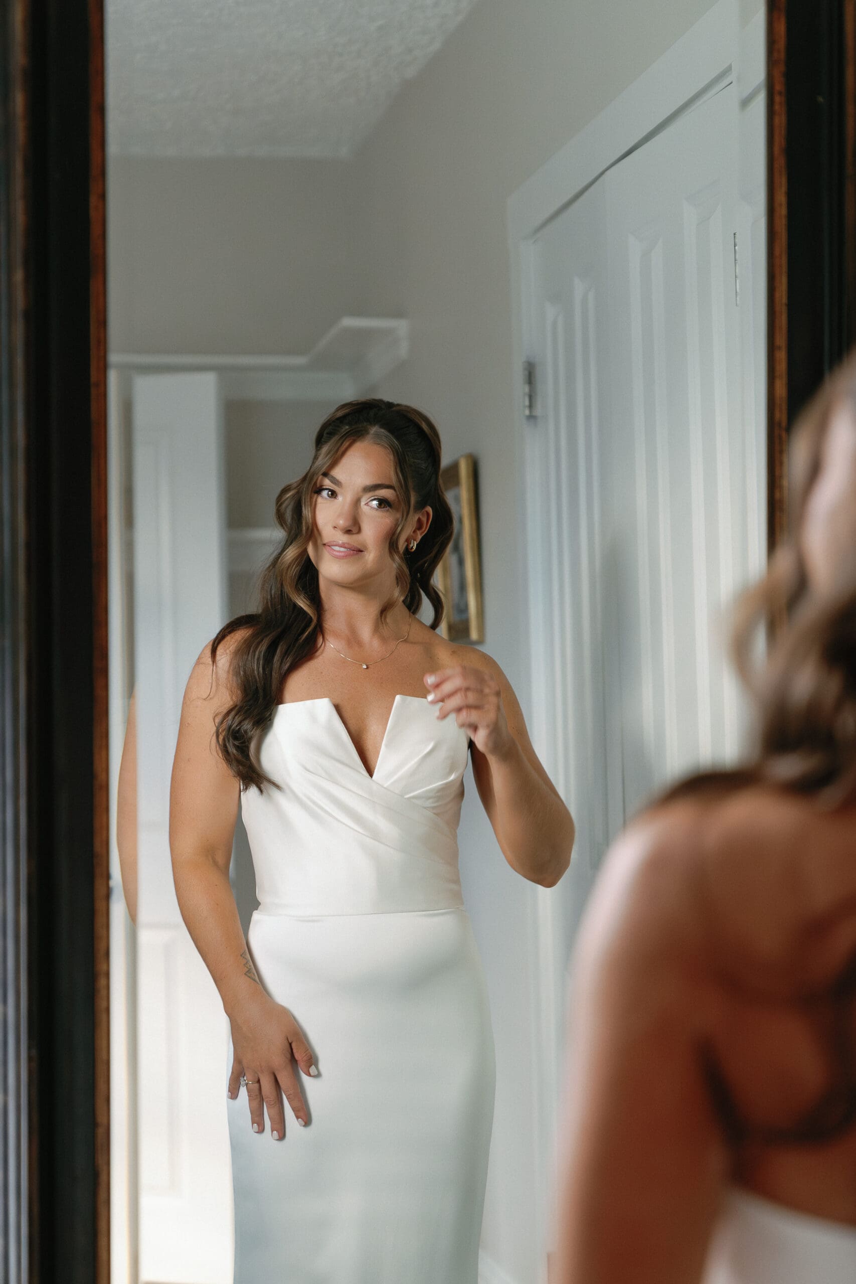 Bride looking in mirror for getting ready photos taken by Shelby Ann Photos