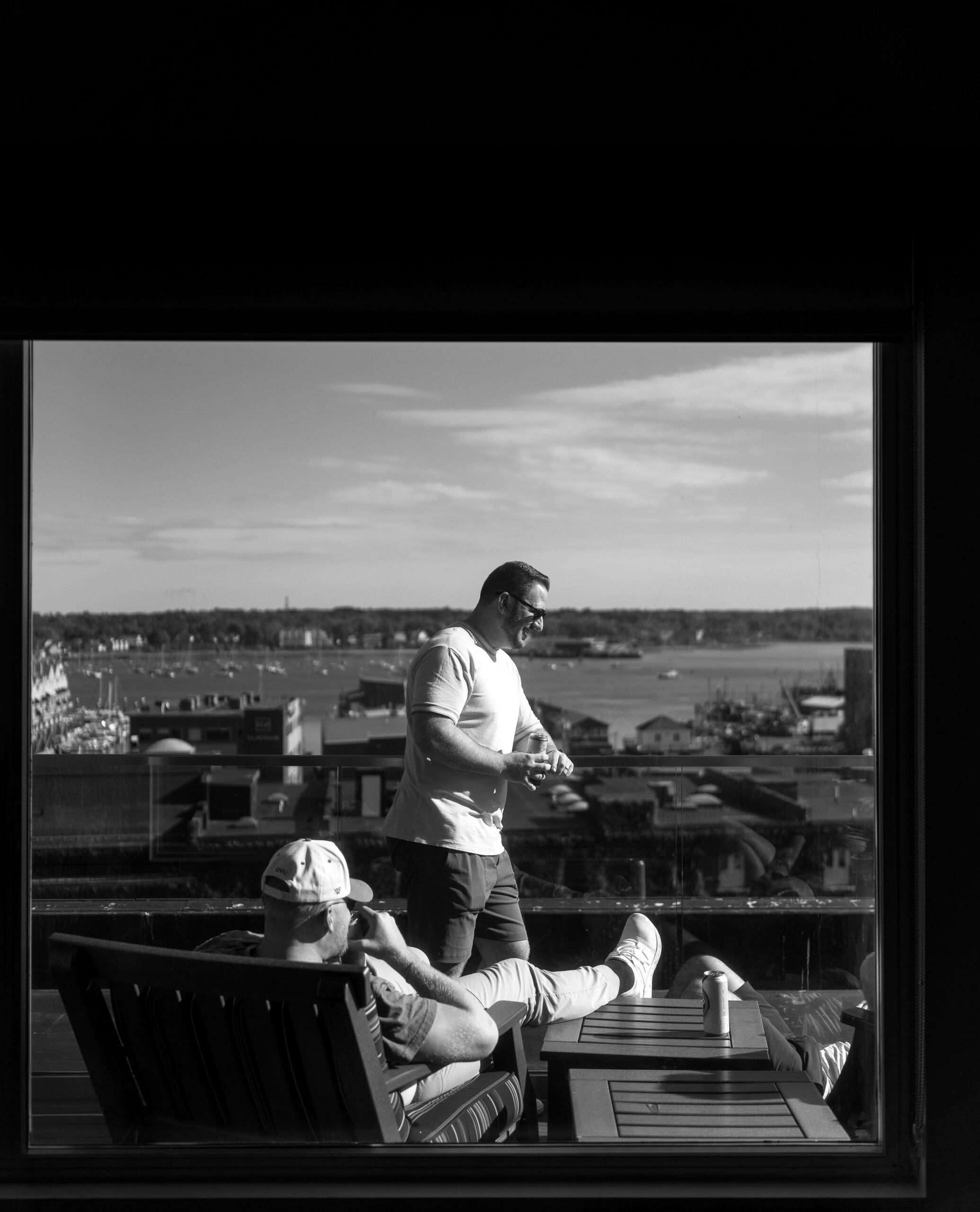 Groomsmen socializing on balcony taken by maine wedding photographer