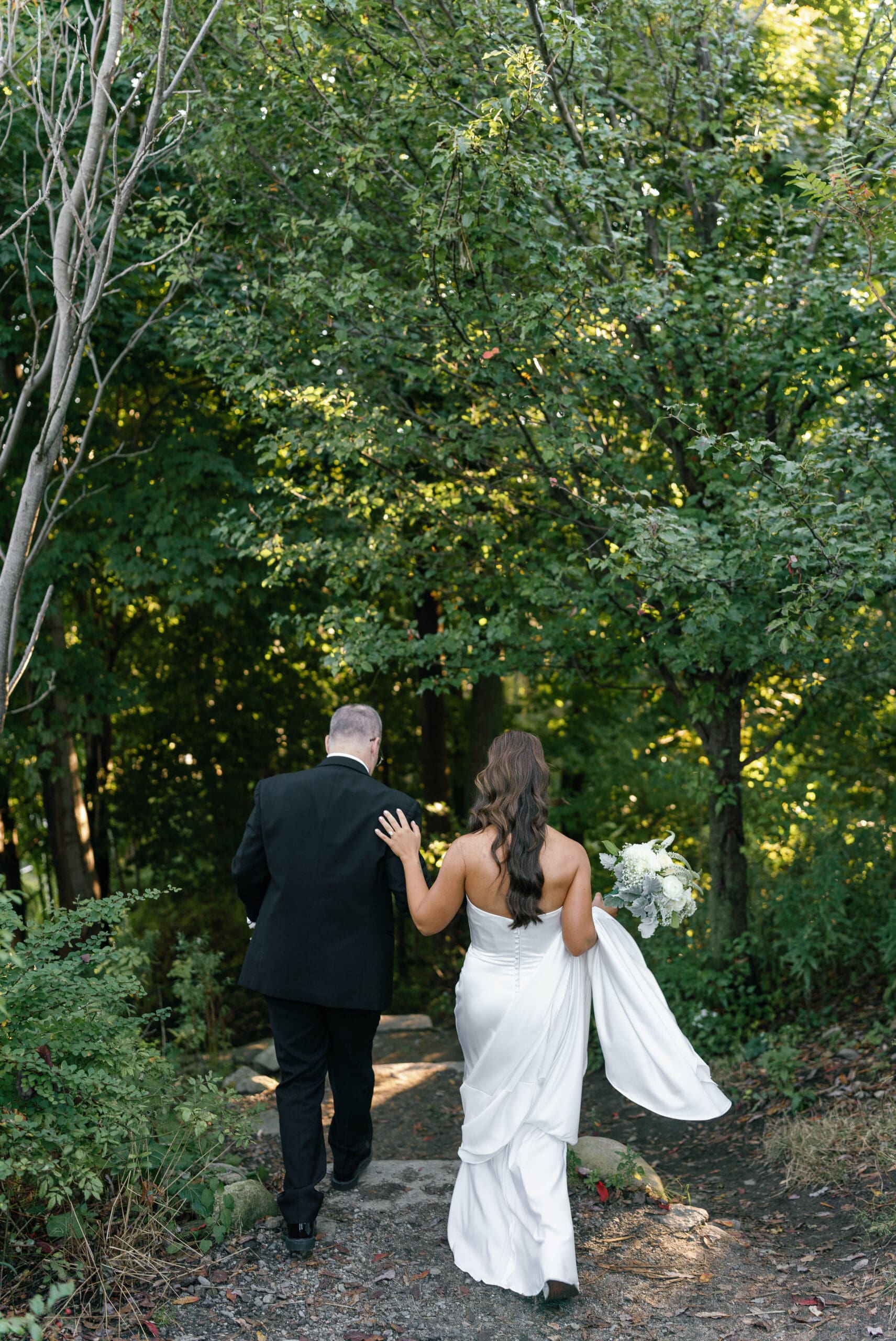 Bride and Father walking down wooded path taken by Maine wedding photographer