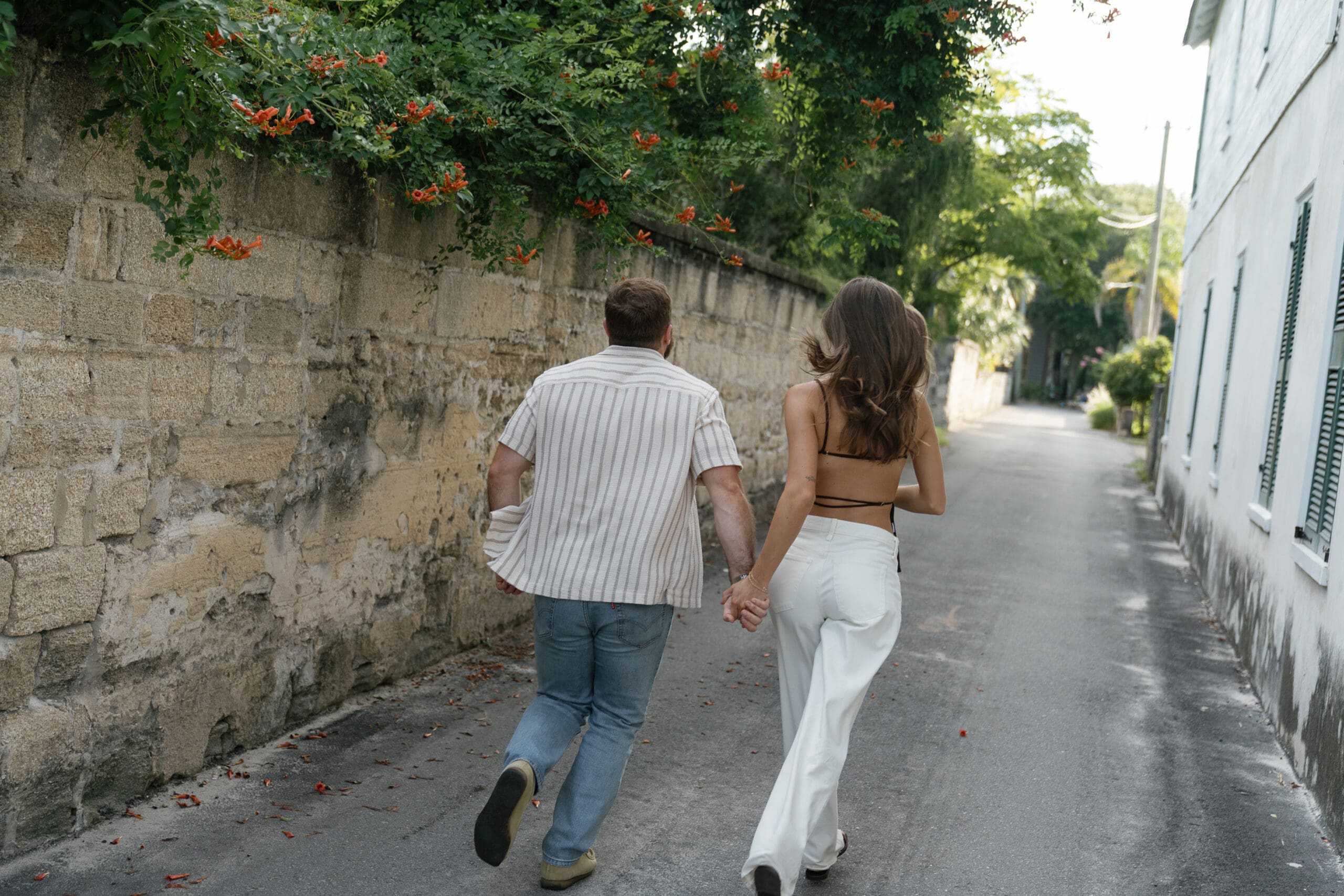 Couple running and holding hands for St. Augustine engagement session by Shelby Ann Photos